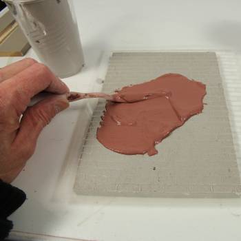 Apply brick stencil over mortar layer